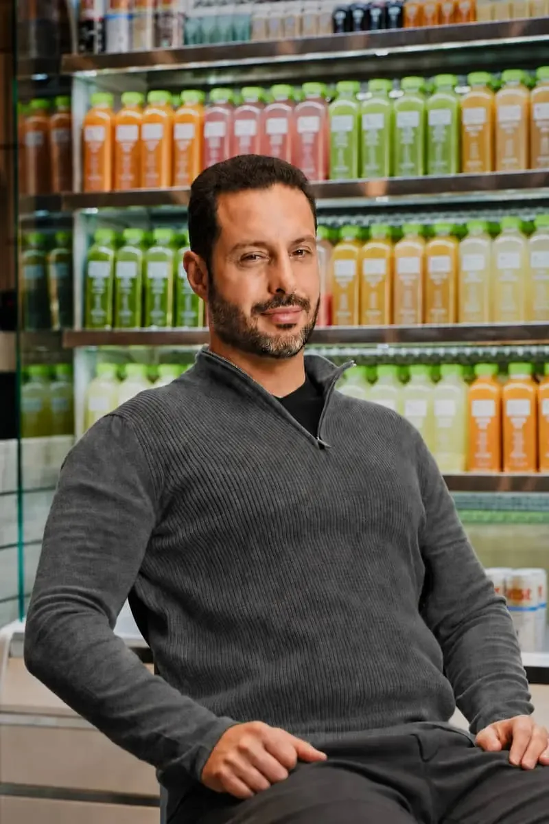 Ross Franklin, founder and CEO of Pure Green, in front of a cooler of cold-pressed juice