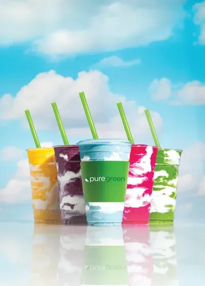 Five Pure Green smoothies against a blue sky